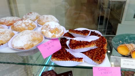 Traditional-desserts-from-Aveiro-showcased-on-a-counter-with-labels-displaying-their-names-and-prices,-Portugal