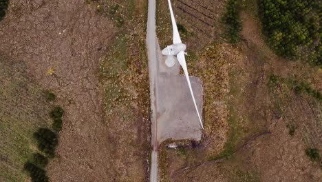 Drone-shot-of-a-single-track-road-near-a-wind-turbine-on-the-Hebrides