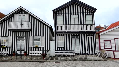 Black-and-white-striped-facade-walls-of-houses-of-Costa-Nova,-Portugal,-day