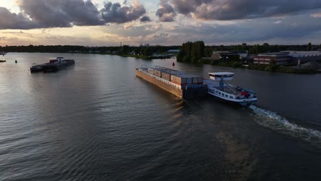 Sonnenuntergang-über-Der-Oude-Maas,-Während-Zwei-Frachtschiffe-Weiterfahren