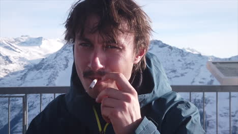 Skier-smokes-a-cigarette-at-a-break-high-in-the-mountains