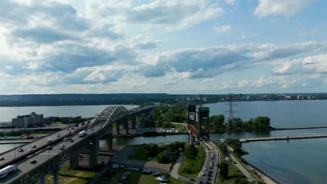 Burlington-Bay-James-N-Allan-Skyway-aerial-flyover-Hamilton-to-Toronto-overlooking-the-CCIW-while-leisure-speed-boat-crosses-the-Burlington-Canal-on-a-sunny-summer-day-at-Inland-Water-Center