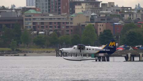 Turbo-Otter-Floatplane-Takes-Off-with-Urban-Waterside-Background-TRACK