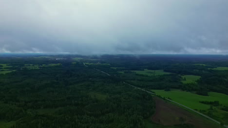 Aerial-drone-view-descending-from-the-clouds-into-a-green-wooded-valley