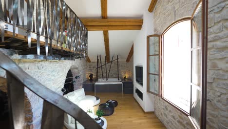 Descending-metal-steps-into-a-living-room,-of-a-guest-house,-the-walls-are-made-of-exposed-stone