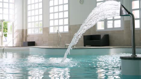 Fountain-in-a-Thermal-Spa-Pool-with-Large-Sunlit-Windows