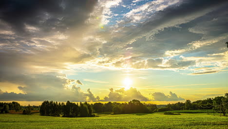 Zeitrafferaufnahme-Des-Sonnenaufgangs-über-Grünem-Grasland-Mit-Dunklen-Wolken,-Die-Im-Morgengrauen-Vorbeiziehen