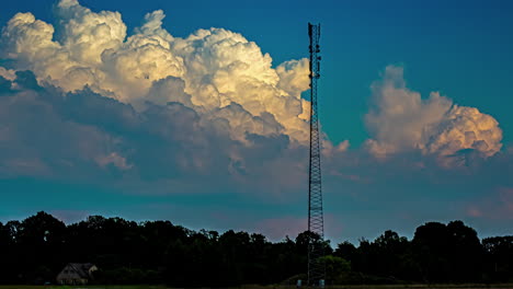 Timelapse-of-big-white-clouds-in-the-blue-sky-behind-a-communication-tower