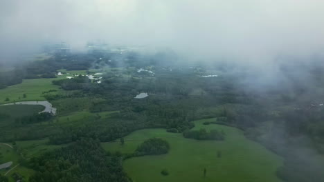 Toma-Aérea-De-Drones-De-Un-Hermoso-Paisaje-Rural-Verde-A-Través-De-Nubes-Blancas-Durante-El-Día