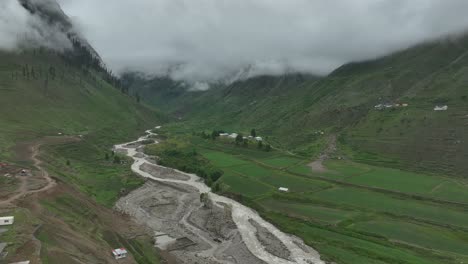 Follow-shot-of-drone-over-the-lake-and-green-valley-in-Naran-Batakundi-in-northern-region-of-Pakistan-with-low-clouds