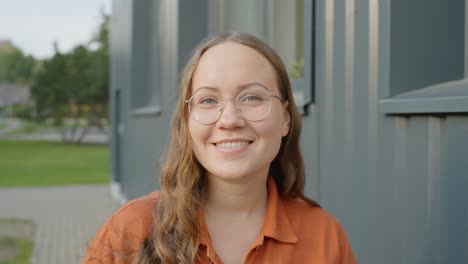 Woman-with-glasses-smiling-at-the-camera,-static-closeup