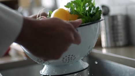 Person-rinsing-some-vegetables-in-a-strainer
