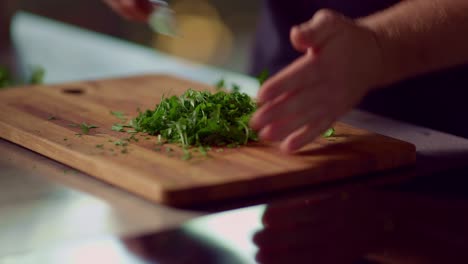 A-man-chops-parsley-on-a-wooden-cutting-board