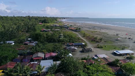 Drone-shot-of-rural-homes-on-the-beach-of-La-Barra-in-the-Colombian-Pacific,-near-Juanchaco-and-Ladrilleros