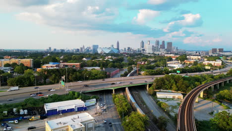 Aerial-view-of-heavy-traffic-on-elevated-multilane-expressway-and-skyline-with-tall-downtown-skyscraper-in-distance