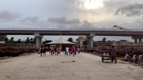 Construction-is-underway-for-a-new-coastal-road,-with-pedestrians-passing-beneath-it