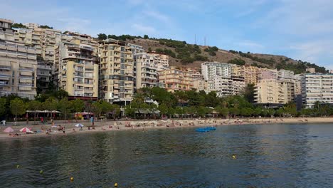 Wunderschöne-Bucht-Von-Saranda-In-Albanien,-Hotels-Mit-Meerblick,-Touristen,-Die-Entlang-Der-Promenade-Flanieren-–-Ein-Faszinierendes-Küstenstadtbild