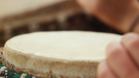 Close-up-of-a-white-woman's-hands-playing-a-bongo-in-slow-motion,-bathed-in-the-soft-light-of-the-late-afternoon