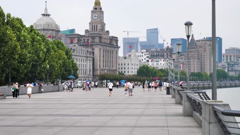 Huangpu-Riverside-Avenue-at-the-famous-Bund-in-Shanghai-with-tourists-and-buildings-in-the-Background,-Slowmotion
