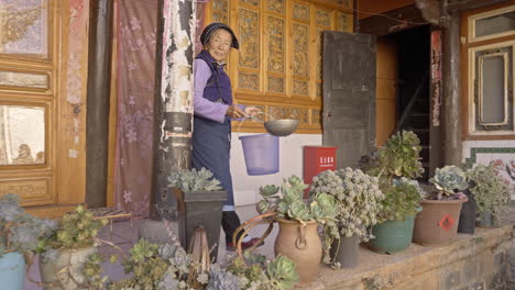 Bai-Ethnic-Minority-Group-Woman-Watering-Plants-in-Yunnan,-China
