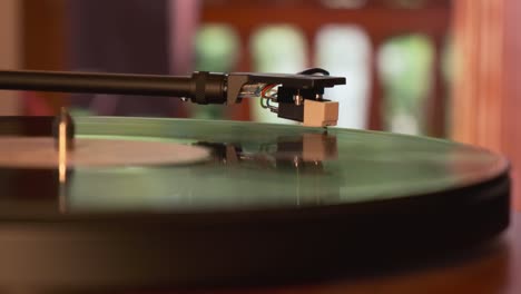 Close-up-view-of-a-turntable-tonearm-and-needle-with-platter-spinning,-slow-motion-4K