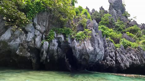 Tropische-Inselausflugsboote-Liegen-Im-Kristallklaren-Türkisfarbenen-Meerwasser-Neben-Schroffen-Felsklippen-In-El-Nido,-Palawan,-Philippinen
