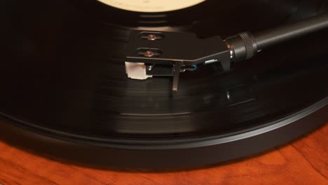 Close-up-view-of-a-turntable-tonearm-with-platter-spinning,-slow-motion-4K