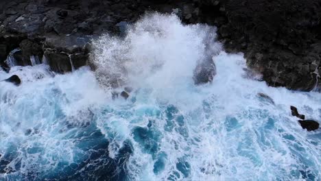 Stationary-pov-of-waves-crashing-against-black-rock-volcanic-cliffs