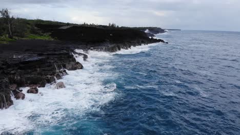 Rise-up-to-stationary-view-of-waves-hitting-volcanic-cliffs