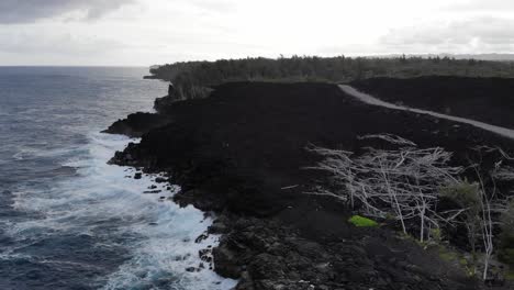 Flying-towards-2018-lava-flow-along-coastline-of-Hawaii-Puna-with-cars-driving-on-top-along-a-new-road