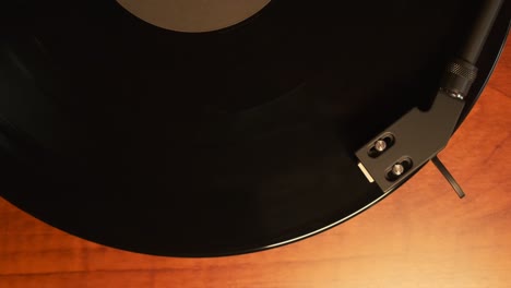 Top-down-view-of-a-turntable-tonearm-with-platter-spinning,-slow-motion-4K