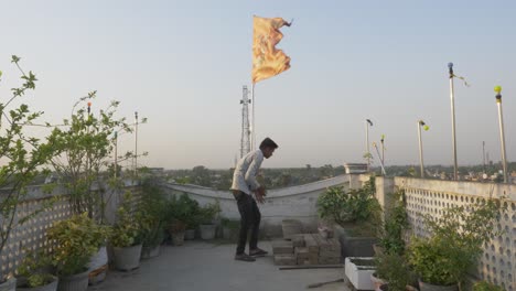 Young-man-at-roof-under-religious-and-cultural-Hindu-flag