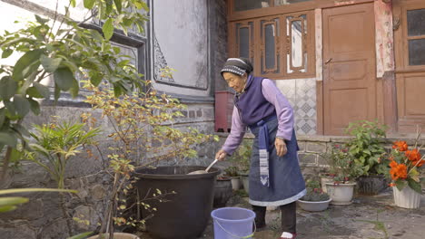 Ethnic-Minority-Bai-Woman-Watering-Flowers-in-Yunnan,-China