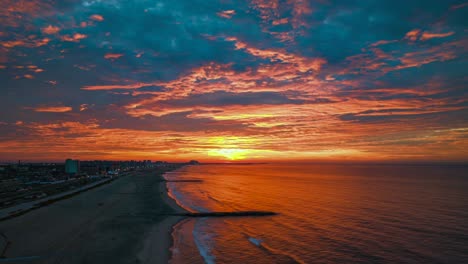 An-aerial-time-lapse-over-Rockaway-Beach,-New-York-during-a-beautiful-and-cloudy-sunrise
