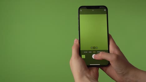 Woman-takes-pictures-with-iPhone-in-front-of-greenscreen