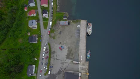 Aerial-revealing-shot-of-a-long-queue-of-cars-parked-on-the-scenic-route-on-Senja-at-the-ferry-port-of-Gryllefjord