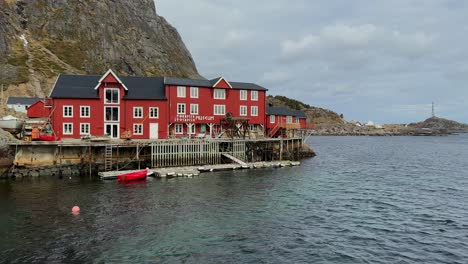 Panning-shot-of-the-Lofoten-Museum-located-in-A-on-a-cloudy-day-with-traditional-Norwegian-red-cabins,-Rorbu