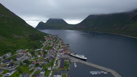 Long-lines-of-cars-waiting-to-get-on-the-ferry-during-summer-in-Gryllefjord,-low-clouds-hanging-around-the-mountains