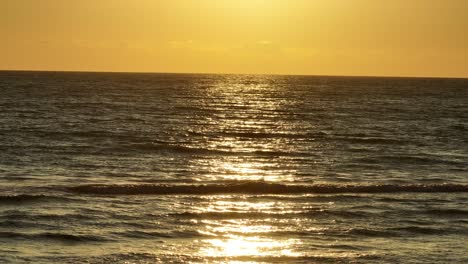 Kleine-Wellen-Auf-Einem-Ruhigen-Meer-Während-Des-Sonnenuntergangs