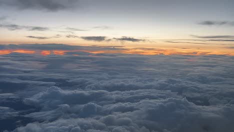 Sunset-view-shot-from-an-airplane-overflying-a-layer-of-clouds-flying-westbound-at-12000m-high