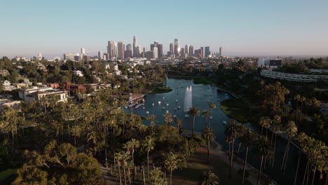 A-Drone-Shot-of-Echo-Park-Lake-with-Downtown-Los-Angeles-in-the-Background-at-Golden-Hour,-Pushing-in-on-Downtown