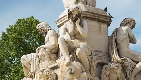 Statues-of-women-on-a-water-fountain-of-Nîmes,-water-flows-from-the-jar