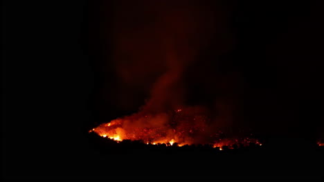 Time-lapse-of-a-smoldering-forest-fire-glowing,-calming-in-the-night-darkness