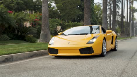 Circling-Yellow-Lamborghini,-Luxury-Sports-Car-Parked-under-Palm-Trees-of-Beverly-Hills,-California