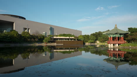 Cheongjajeong-Pavilion-and-National-Museum-of-Korea-on-Summer-Sunny-Day-with-Reflections-in-Water-in-Seoul-City-Yongsan-District---pan-reveal