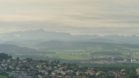 Kleine-Stadt-Auf-Dem-Land-Mit-Den-Alpen-Im-Hintergrund