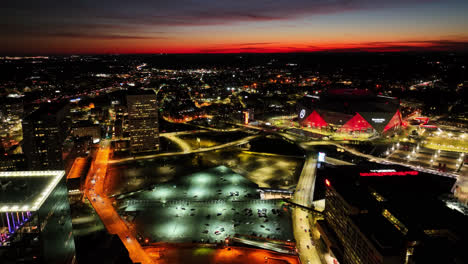 Luftaufnahme-Einer-Drohne,-Die-Den-Verkehr-Auf-Der-Straße-Und-Die-Beleuchtung-Des-Mercedes-Benz-Stadions-In-Atlanta-Nach-Sonnenuntergang-Am-Horizont-Zeigt