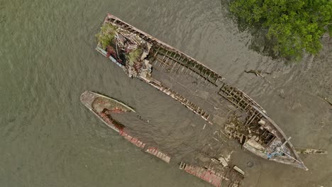 Aerial-overhead-view-of-wooden-boat-wrecks-near-the-coast-of-the-Philippines