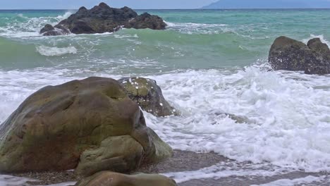 Slow-Motion-Ocean-Waves-Crashing-Over-Rocks-at-Banbanon-Beach-in-Surigao-Del-Norte,-Philippines