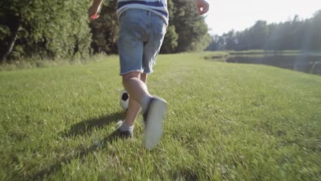 Rear-view-video-of-boy-playing-football-on-the-grass